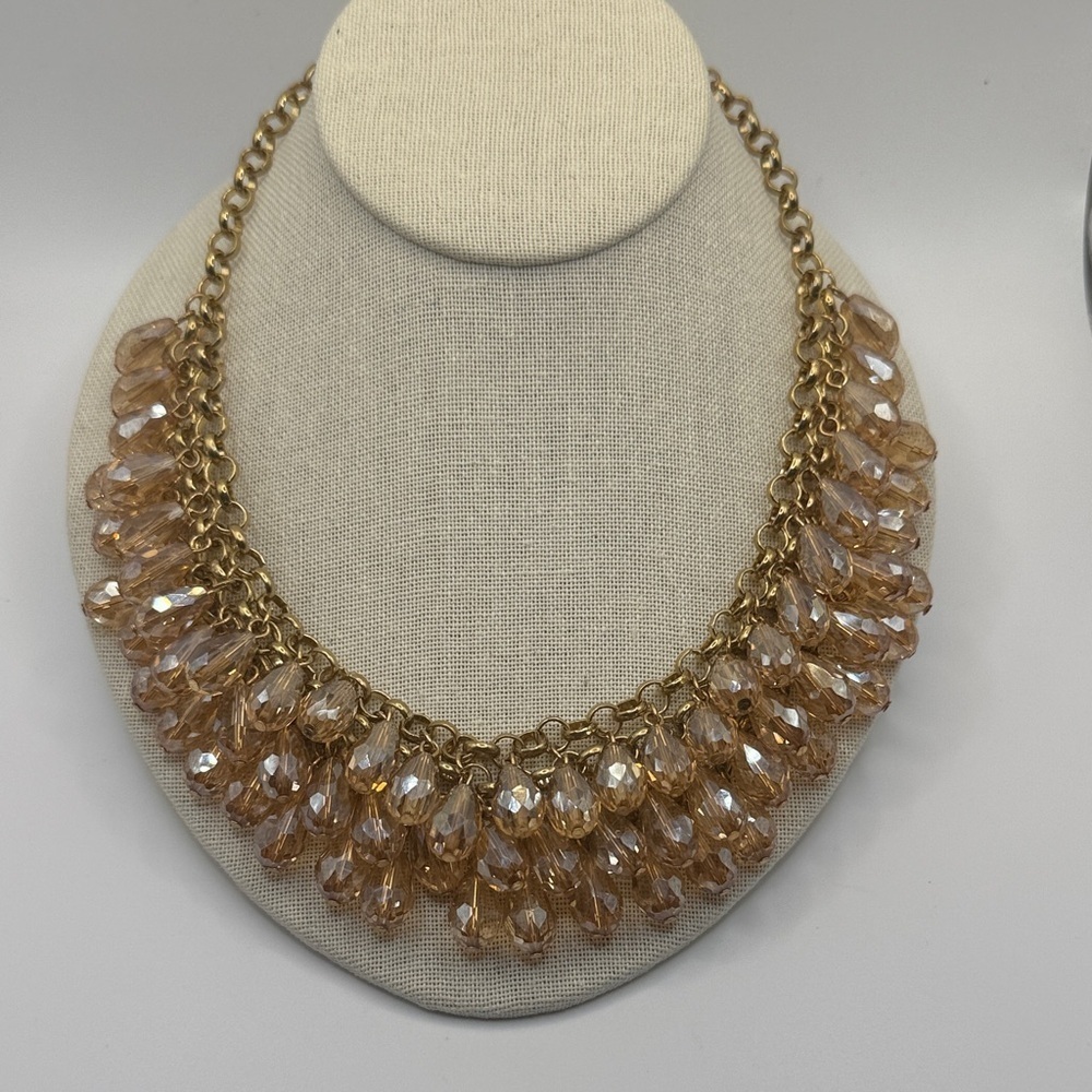 gold-tone chain necklace cascade of peach-colored, faceted glass teardrop beads.